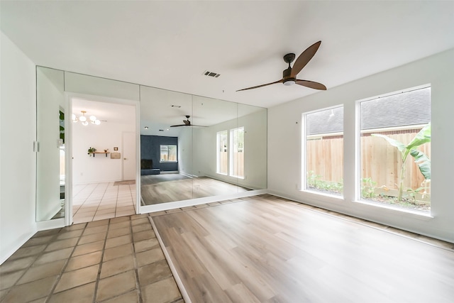 unfurnished living room with ceiling fan and tile patterned floors