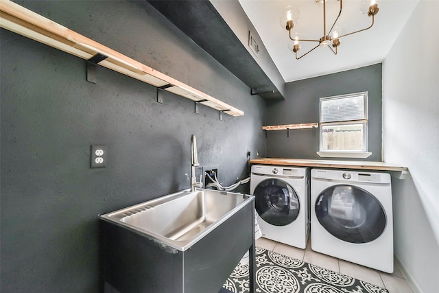 laundry room featuring an inviting chandelier, independent washer and dryer, light tile patterned floors, and sink