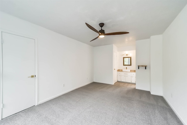 interior space with light colored carpet, connected bathroom, and ceiling fan