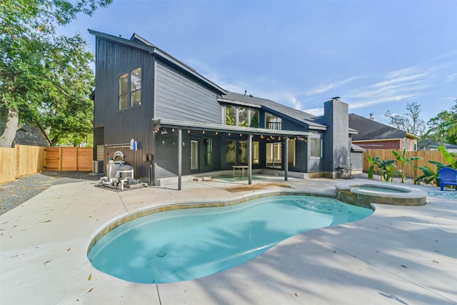 exterior space featuring an in ground hot tub and a patio area