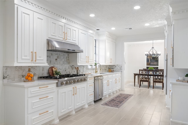 kitchen featuring appliances with stainless steel finishes, a textured ceiling, and white cabinetry