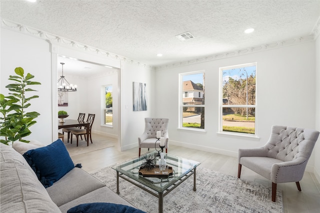 living room with a textured ceiling, light hardwood / wood-style flooring, and plenty of natural light