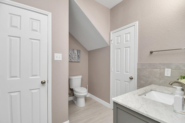 18306 Fresh Air Ct, Houston, TX 77084 - bathroom featuring tile walls, wood finished floors, vanity, baseboards, and toilet