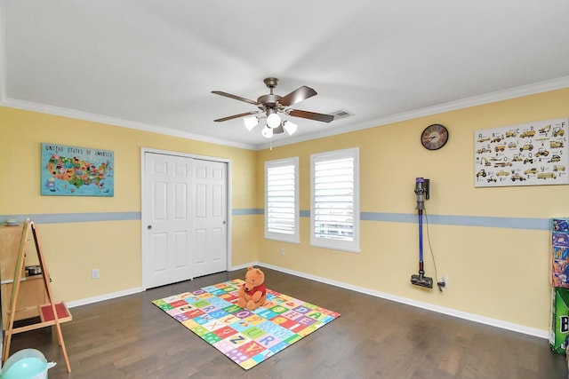 18306 Fresh Air Ct, Houston, TX 77084 - playroom featuring visible vents, crown molding, baseboards, ceiling fan, and dark wood-style floors