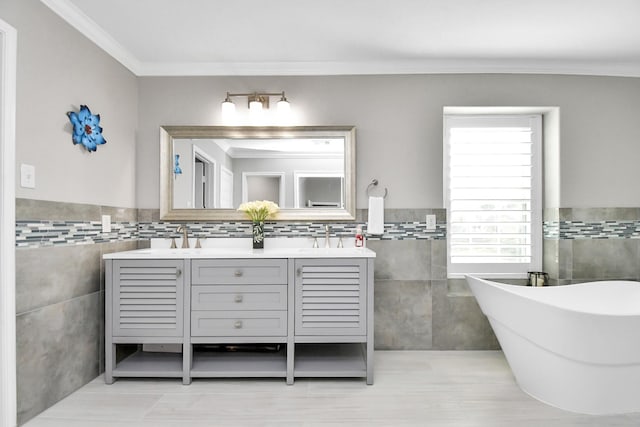 18306 Fresh Air Ct, Houston, TX 77084 - bathroom with a freestanding bath, a sink, double vanity, tile walls, and ornamental molding
