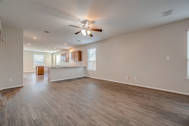 unfurnished living room with plenty of natural light, hardwood / wood-style floors, and ceiling fan