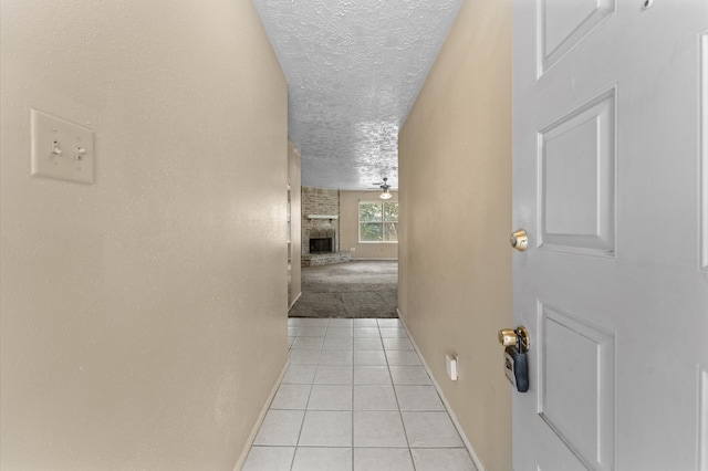 hallway featuring a textured ceiling and light tile patterned flooring