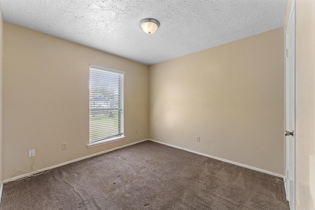 unfurnished room with a textured ceiling and carpet flooring