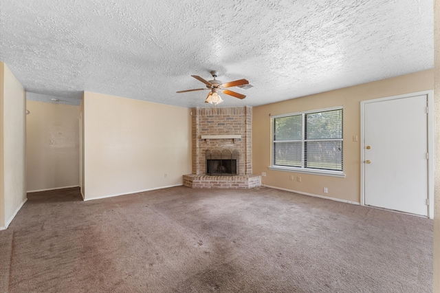 unfurnished living room featuring carpet, ceiling fan, a fireplace, and a textured ceiling