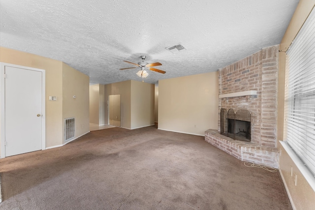 unfurnished living room featuring carpet floors, a textured ceiling, a fireplace, and ceiling fan