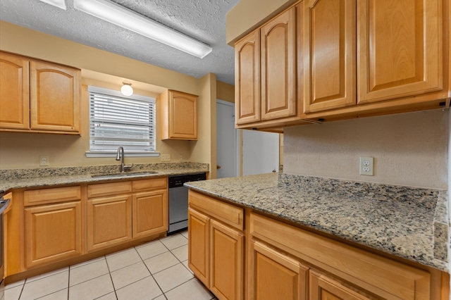 kitchen with a textured ceiling, light tile patterned flooring, sink, appliances with stainless steel finishes, and light stone countertops