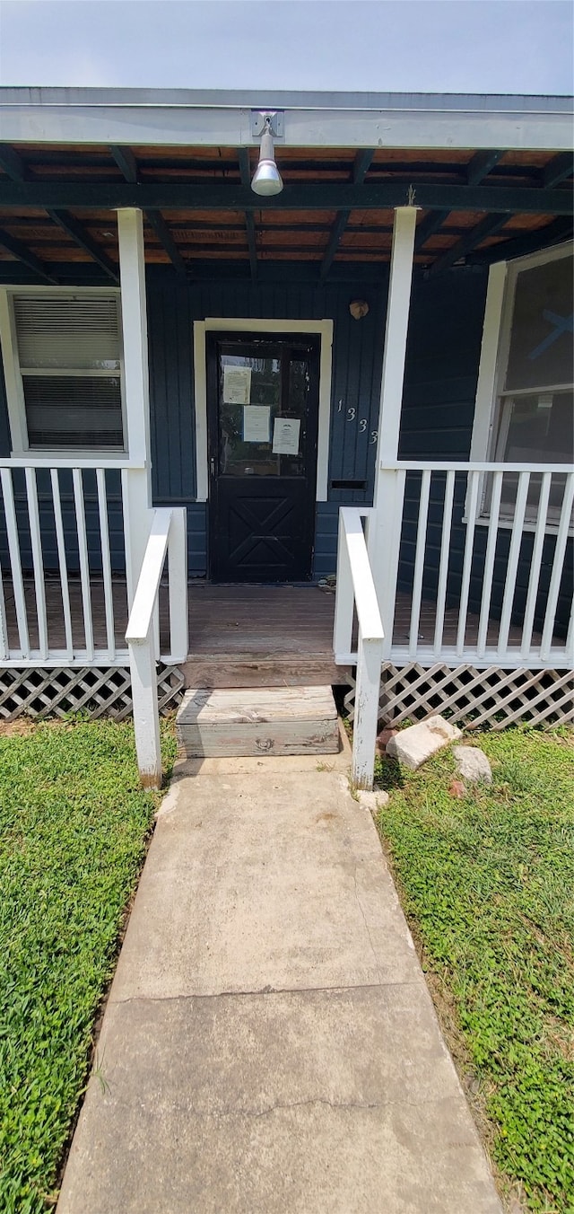 view of exterior entry featuring covered porch