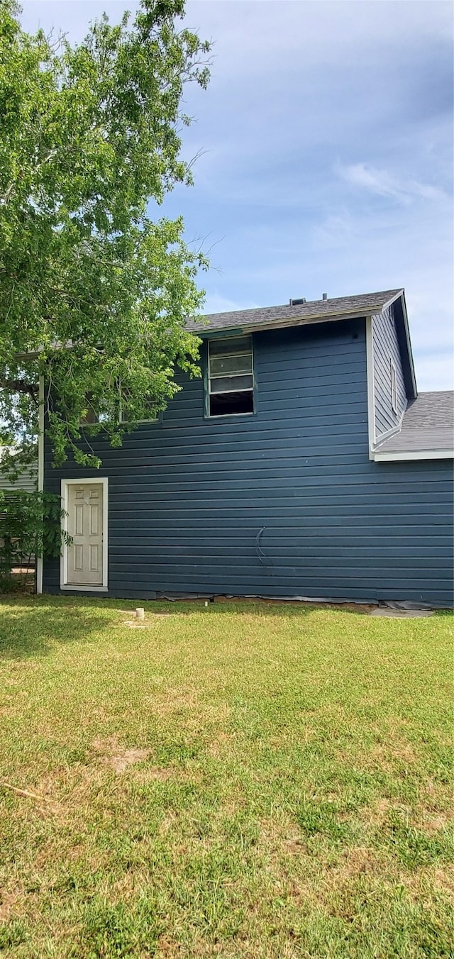 view of side of home with a yard