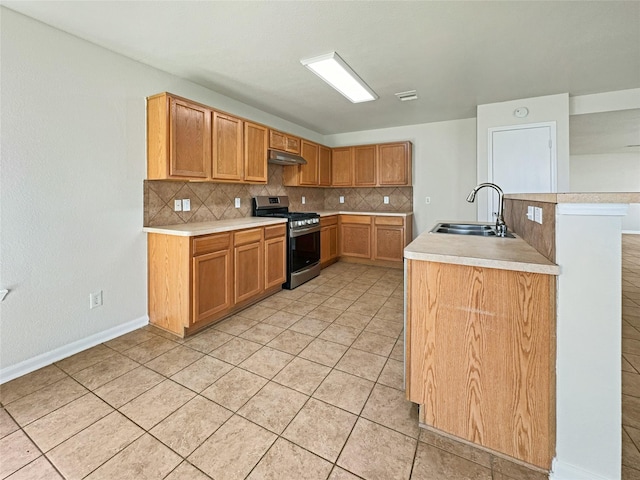 kitchen featuring light countertops, stainless steel gas stove, a sink, and backsplash