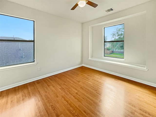 empty room with ceiling fan and light hardwood / wood-style floors