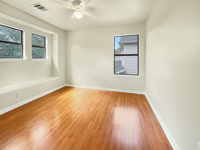 spare room featuring plenty of natural light, ceiling fan, and light wood-type flooring