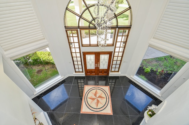 tiled foyer featuring a high ceiling and a notable chandelier