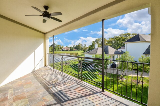 balcony with a water view and ceiling fan