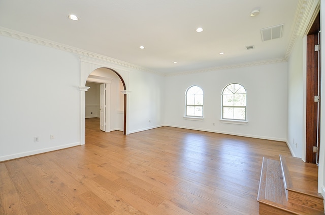 empty room featuring ornamental molding and light hardwood / wood-style flooring