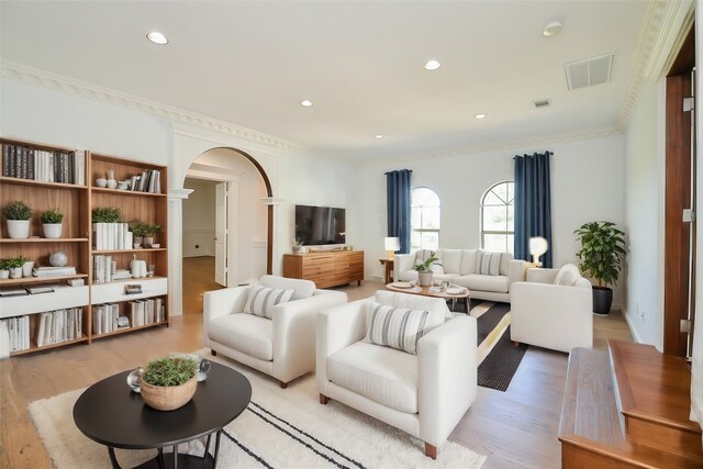 living room with light hardwood / wood-style floors and crown molding