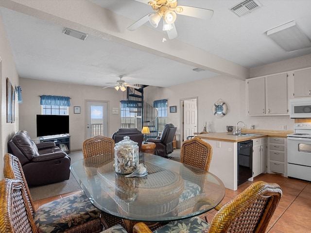 tiled dining room with ceiling fan and sink