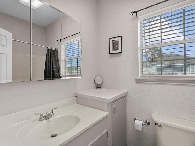 bathroom featuring toilet, a shower with curtain, and vanity