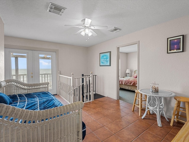 125 Driftwood Ct, Surfside Beach, TX 77541 - tiled bedroom featuring french doors, a textured ceiling, access to exterior, visible vents, and a textured wall