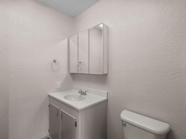 125 Driftwood Ct, Surfside Beach, TX 77541 - bathroom featuring vanity, a textured ceiling, and toilet