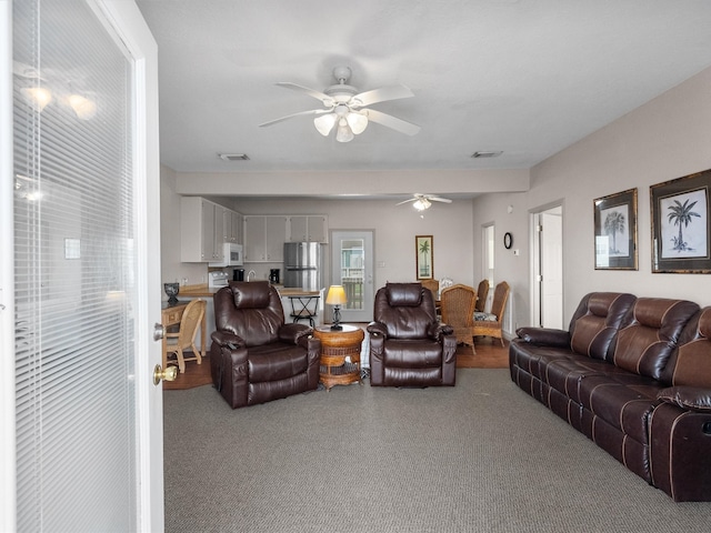 carpeted living room with ceiling fan