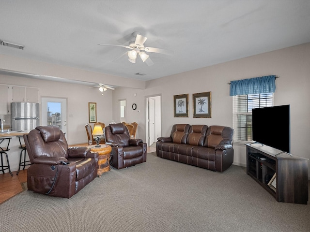 125 Driftwood Ct, Surfside Beach, TX 77541 - carpeted living room featuring visible vents, a ceiling fan, and a sink