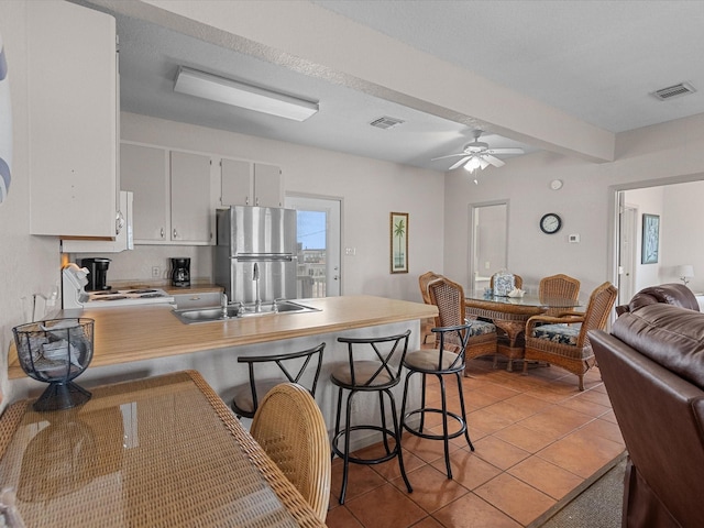 125 Driftwood Ct, Surfside Beach, TX 77541 - kitchen with visible vents, freestanding refrigerator, a sink, and light tile patterned flooring