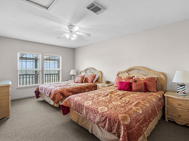 125 Driftwood Ct, Surfside Beach, TX 77541 - carpeted bedroom with a textured ceiling, ceiling fan, visible vents, and attic access
