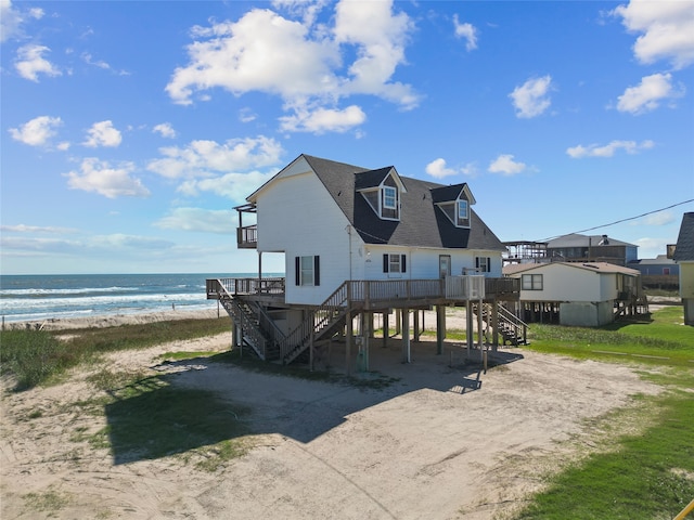 back of property featuring a water view and a beach view