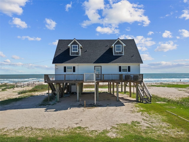 125 Driftwood Ct, Surfside Beach, TX 77541 - view of front of property featuring roof with shingles, stairs, a deck with water view, a carport, and driveway