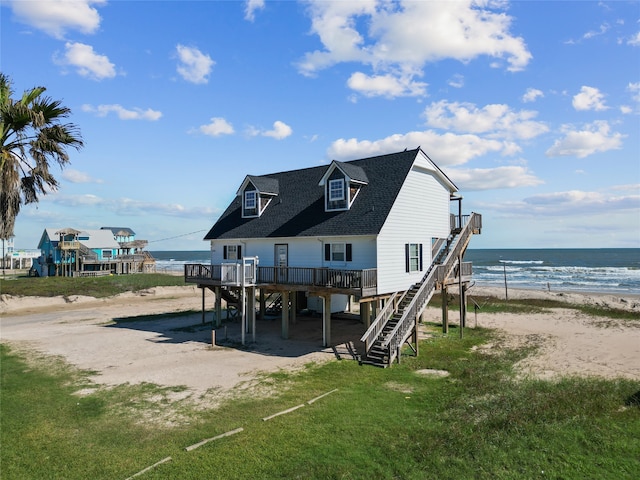 rear view of house featuring a view of the beach and a deck with water view