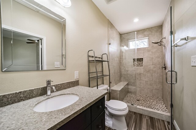 full bathroom with vanity, toilet, wood finished floors, and a shower stall