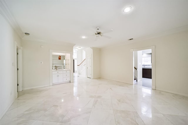 spare room with marble finish floor, crown molding, a sink, and a ceiling fan