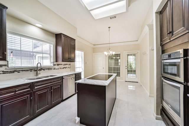 kitchen featuring visible vents, a sink, a kitchen island, tasteful backsplash, and stainless steel appliances