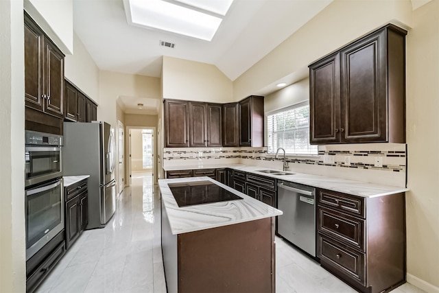 kitchen featuring decorative backsplash, visible vents, appliances with stainless steel finishes, a sink, and a center island