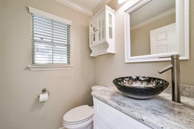 bathroom with vanity, toilet, and crown molding