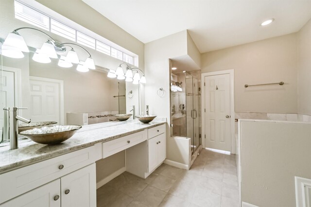 bathroom featuring tile patterned flooring, a shower stall, and vanity