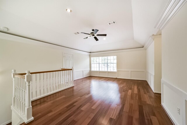 spare room featuring wood finished floors, visible vents, ornamental molding, wainscoting, and a decorative wall