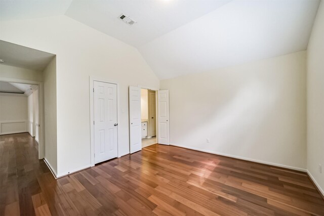 unfurnished bedroom featuring lofted ceiling, wood finished floors, visible vents, and baseboards