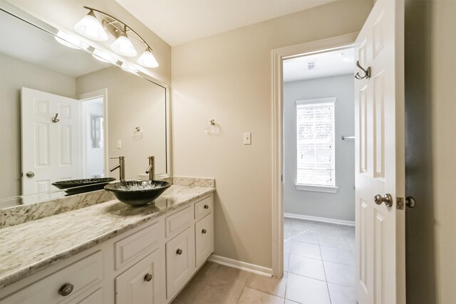 bathroom featuring tile patterned flooring, vanity, and baseboards