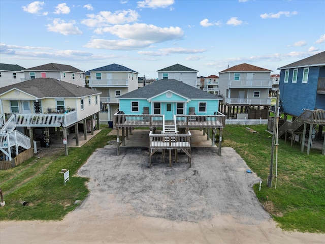 rear view of house featuring a carport, a deck, and a yard