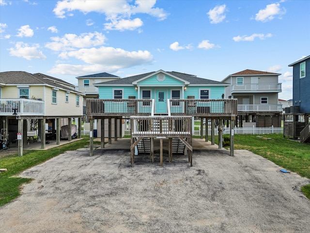 back of house with a wooden deck, a carport, and a yard