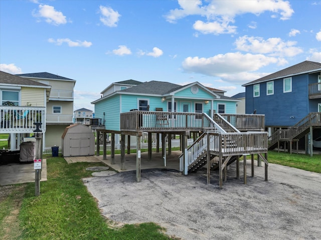 rear view of property with a shed, a deck, and central AC unit