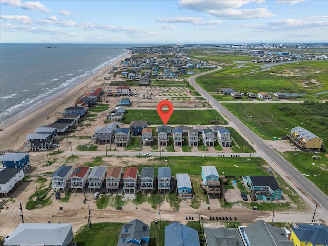 birds eye view of property featuring a water view and a beach view