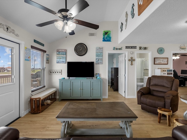 living room with a ceiling fan, baseboards, vaulted ceiling, visible vents, and light wood-style floors