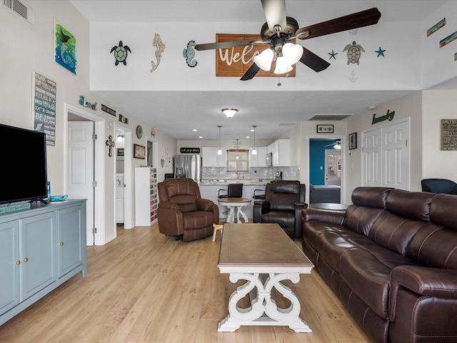 living room with ceiling fan and light hardwood / wood-style flooring